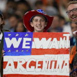 
              A U.S. fan holds a placard before the World Cup round of 16 soccer match between the Netherlands and the United States, at the Khalifa International Stadium in Doha, Qatar, Saturday, Dec. 3, 2022. (AP Photo/Ebrahim Noroozi)
            