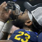 
              Michigan linebacker Michael Barrett kisses the trophy as he celebrates with teammates after defeating Purdue in the Big Ten championship NCAA college football game, early Sunday, Dec. 4, 2022, in Indianapolis. Michigan won, 43-22. (AP Photo/Darron Cummings)
            