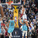
              Denver Nuggets forward Aaron Gordon, right, flies over Phoenix Suns guard Landry Shamet to dunk the ball for a basket in overtime of an NBA basketball game Sunday, Dec. 25, 2022, in Denver. (AP Photo/David Zalubowski)
            