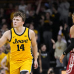 
              Iowa guard Carter Kingsbury (14) celebrates ahead of Wisconsin guard Jordan Davis (2) after making a 3-point basket during the first half of an NCAA college basketball game, Sunday, Dec. 11, 2022, in Iowa City, Iowa. (AP Photo/Charlie Neibergall)
            