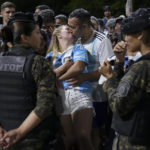
              Fans kiss while waiting for the arrival of the Argentine soccer team that won the World Cup outside the AFA training grounds in Buenos Aires, Argentina, Tuesday, Dec. 20, 2022. (AP Photo/Matilde Campodonico)
            