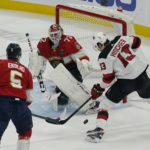 
              Florida Panthers goaltender Sergei Bobrovsky (72) deflects a shot on goal by New Jersey Devils center Nico Hischier (13) during first period of an NHL hockey game, Wednesday, Dec. 21, 2022, in Sunrise, Fla. (AP Photo/Marta Lavandier)
            