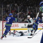 
              Vancouver Canucks' Brock Boeser (6) celebrates Elias Pettersson's goal against Seattle Kraken goalie Martin Jones (30) during the third period of an NHL hockey game Thursday, Dec. 22, 2022, in Vancouver, British Columbia. (Darryl Dyck/The Canadian Press via AP)
            