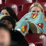 
              Fans are wrapped up in blankets as they watch in the cold during the first half of the Gasparilla Bowl NCAA college football game between Wake Forest and Missouri Friday, Dec. 23, 2022, in Tampa, Fla. (AP Photo/Chris O'Meara)
            