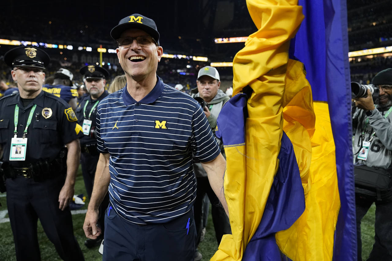 Michigan head coach Jim Harbaugh smiles after defeating Purdue in the Big Ten championship NCAA col...