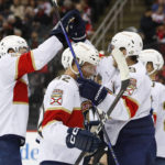
              Florida Panthers Gustav Forsling (42) celebrates with teammates Zac Dalpe, left, and Matthew Tkachuk, right, after scoring a goal against the New Jersey Devils during the second period of an NHL hockey game, Saturday Dec. 17, 2022, in Newark, N.J. (AP Photo/Noah K. Murray)
            