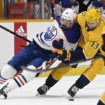 
              Edmonton Oilers center Devin Shore (14) and Nashville Predators center Yakov Trenin (13) battle for the puck during the first period of an NHL hockey game Monday, Dec. 19, 2022, in Nashville, Tenn. (AP Photo/Mark Zaleski)
            