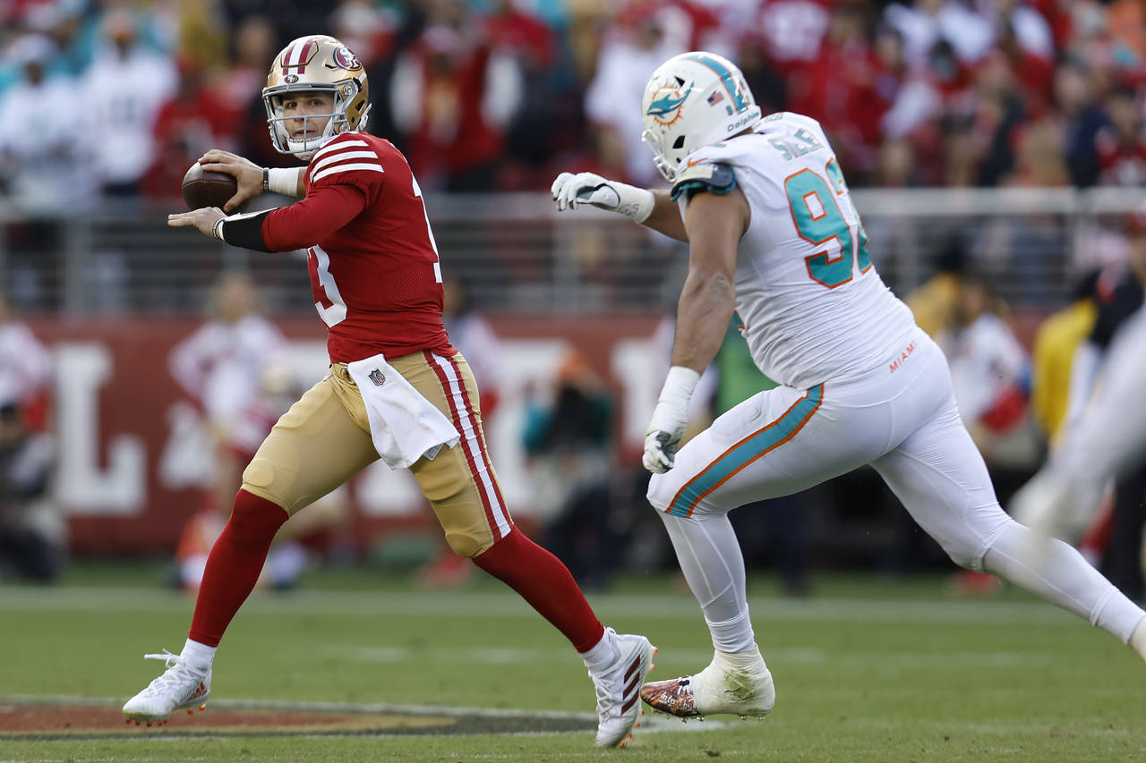 San Francisco 49ers quarterback Brock Purdy, left, passes against Miami Dolphins defensive tackle Z...