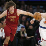 
              Cleveland Cavaliers guard Caris LeVert, left to right, center Robin Lopez and New York Knicks center Isaiah Hartenstein chase after a loose ball during the first half of an NBA basketball game, Sunday, Dec. 4, 2022, in New York. (AP Photo/John Munson)
            