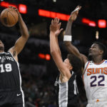 
              San Antonio Spurs' Alize Johnson (19) and Isaiah Roby, center, grab for the rebound against Phoenix Suns' Deandre Ayton (22) during the first half of an NBA basketball game, Sunday, Dec. 4, 2022, in San Antonio. (AP Photo/Darren Abate)
            