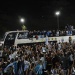 
              Fans welcome home the players from the Argentine soccer team that won the World Cup after they landed at Ezeiza airport in Buenos Aires, Argentina, Tuesday, Dec. 20, 2022. (AP Photo/Rodrigo Abd)
            