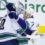 
              Vancouver Canucks goalie Spencer Martin, left, and forward Conor Garland celebrate defeating the Calgary Flames in a shootout during an NHL hockey game in Calgary, Alberta, Wednesday, Dec. 14, 2022. (Jeff McIntosh/The Canadian Press via AP)
            