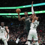 
              Boston Celtics guard Marcus Smart (36) passes out from under the basket as Milwaukee Bucks forward Giannis Antetokounmpo defends during the second half of an NBA basketball game, Sunday, Dec. 25, 2022, in Boston. (AP Photo/Mary Schwalm)
            