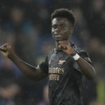 
              Arsenal's Bukayo Saka celebrates after the end of the English Premier League soccer match between Brighton and Hove Albion and Arsenal and at the AMEX Community Stadium in Brighton, England, Saturday, Dec. 31, 2022. Arsenal won the game 4-2.(AP Photo/Alastair Grant)
            