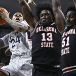 
              Connecticut's Jordan Hawkins (24) shoots as Oklahoma State's Quion Williams (13) and John-Michael Wright (51) defend in the first half of an NCAA college basketball game, Thursday, Dec. 1, 2022, in Storrs, Conn. (AP Photo/Jessica Hill)
            