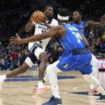 
              Minnesota Timberwolves center Naz Reid (11) works towards the basket while defended by Dallas Mavericks guard Kemba Walker (34), front, and forward Dorian Finney-Smith during the first half of an NBA basketball game, Monday, Dec. 19, 2022, in Minneapolis. (AP Photo/Abbie Parr)
            