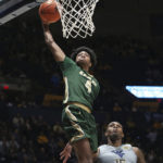 
              UAB guard Eric Gaines (4) shoots while defended by West Virginia forward Jimmy Bell Jr. (15) during the first half of an NCAA college basketball game in Morgantown, W.Va., Saturday, Dec. 10, 2022. (AP Photo/Kathleen Batten)
            