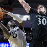 
              Xavier guard Souley Boum, left, is fouled by Cincinnati forward Viktor Lakhin as he drives to the basket during the second half of an NCAA college basketball game, Saturday, Dec. 10, 2022, in Cincinnati. (AP Photo/Aaron Doster)
            
