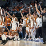 
              Texas guard Tyrese Hunter (4) and the Texas bench watch the flight of Hunter's 3-pointer during the second half of an NCAA college basketball game against Stanford, Sunday, Dec. 18, 2022, in Dallas. Texas won 72-62. (AP Photo/Jeffrey McWhorter)
            