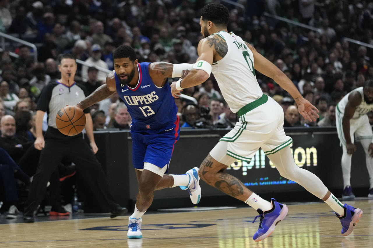 Los Angeles Clippers' Paul George (13) drives toward the basket as he is pressured by Boston Celtic...
