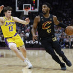 
              Cleveland Cavaliers guard Donovan Mitchell (45) drives against Los Angeles Lakers guard Austin Reaves (15) during the second half of an NBA basketball game Tuesday, Dec. 6, 2022, in Cleveland. (AP Photo/Ron Schwane)
            
