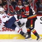 
              Washington Capitals' Nic Dowd, left, is knocked down by Calgary Flames' MacKenzie Weegar during the first period of an NHL hockey game Saturday, Dec. 3, 2022, in Calgary, Alberta. (Larry MacDougal/The Canadian Press via AP)
            