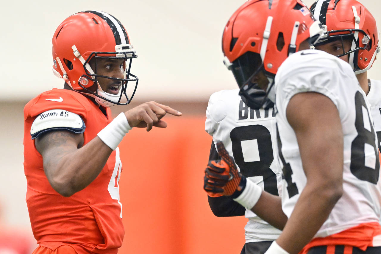Cleveland Browns quarterback Deshaun Watson, left, talks to teammates during an NFL football practi...