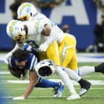 
              Indianapolis Colts' Michael Pittman Jr. (11) helmet comes off as he is tackled by Los Angeles Chargers' Derwin James Jr. (3) and Drue Tranquill (49) during the first half of an NFL football game, Monday, Dec. 26, 2022, in Indianapolis. (AP Photo/AJ Mast)
            
