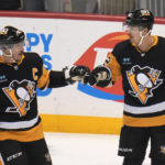 
              Pittsburgh Penguins' Kasperi Kapanen (42) celebrates with Sidney Crosby (87) after Kapanen scored during the first period of the team's NHL hockey game against the St. Louis Blues in Pittsburgh, Saturday, Dec. 3, 2022. It was Kapanen's second goal of the period. (AP Photo/Gene J. Puskar)
            