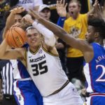 
              Missouri's Noah Carter, center, fights his way between Kansas' K.J. Adams Jr., right, and Jalen Wilson, left, during the first half of an NCAA college basketball game Saturday, Dec. 10, 2022, in Columbia, Mo. (AP Photo/L.G. Patterson)
            