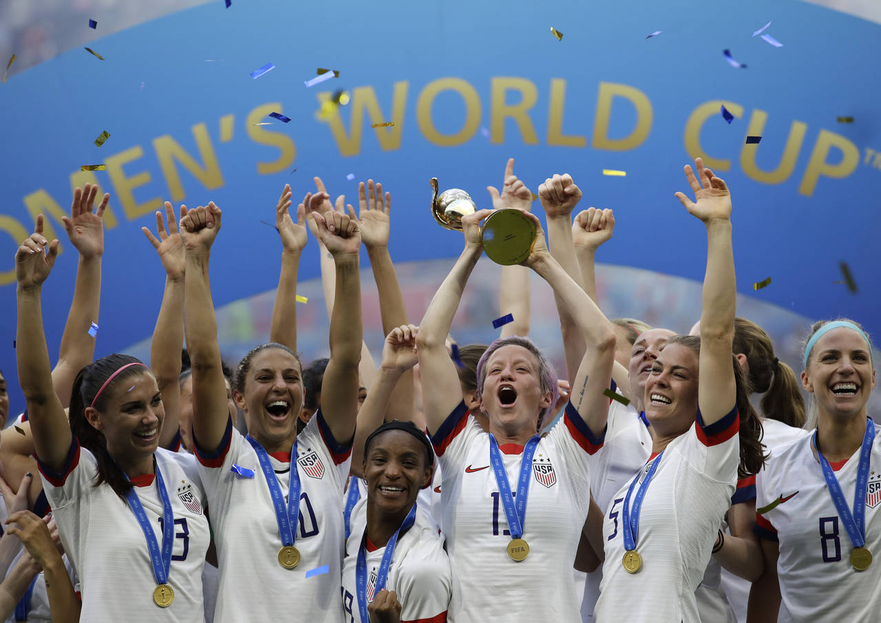 FILE - United States' Megan Rapinoe lifts up a trophy after winning the Women's World Cup final soc...