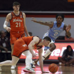 
              Virginia Tech's Hunter Cattoor stubbles while guarded by North Carolina's Caleb Love in the first half a NCAA college basketball game in Blacksburg Va., Sunday Dec. 4, 2022. (Matt Gentry/The Roanoke Times via AP)
            