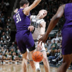 
              Michigan State's Joey Hauser, center, collides with Northwestern's Robbie Beran during the second half of an NCAA college basketball game, Sunday, Dec. 4, 2022, in East Lansing, Mich. (AP Photo/Al Goldis)
            