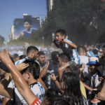 
              Soccer fans waiting to see the Argentine soccer team that won the World Cup tournament are sprayed with water by municipal workers in Buenos Aires, Argentina, Tuesday, Dec. 20, 2022. (AP Photo/Rodrigo Abd)
            