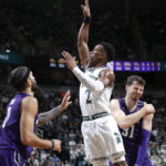 
              Michigan State's Tyson Walker, center, puts up a shot against Northwestern's Boo Buie, left, and Robbie Beran during the first half of an NCAA college basketball game, Sunday, Dec. 4, 2022, in East Lansing, Mich. (AP Photo/Al Goldis)
            