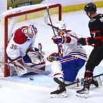 
              Montreal Canadiens goaltender Sam Montembeault (35) makes a save as defenseman Joel Edmundson (44) tries to block out Ottawa Senators left wing Brady Tkachuk (7) during the third period of an NHL hockey game in Ottawa, on Wednesday, Dec. 14, 2022. (Justin Tang/The Canadian Press via AP)
            