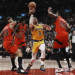 
              Los Angeles Lakers' Russell Westbrook drives between Toronto Raptors' Gary Trent Jr., left, and Christian Koloko during the first half of an NBA basketball game Wednesday, Dec. 7, 2022, in Toronto. (Chris Young/The Canadian Press via AP)
            