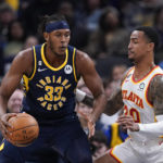 
              Indiana Pacers' Myles Turner (33) is defended by Atlanta Hawks' John Collins (20) during the first half of an NBA basketball game Tuesday, Dec. 27, 2022, in Indianapolis. (AP Photo/Darron Cummings)
            