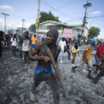 
              A protester carries a piece of wood simulating a weapon during a protest demanding the resignation of Prime Minister Ariel Henry, in the Petion-Ville area of Port-au-Prince, Haiti, on Oct. 3, 2022. (AP Photo/Odelyn Joseph)
            