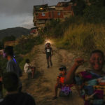 
              Children play on a dirt road in the hilly Catia neighborhood of Caracas, Venezuela, on Jan. 2, 2022. (AP Photo/Matias Delacroix)
            