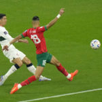 
              Morocco's Jawad El Yamiq, front tries to block a shot from Portugal's Cristiano Ronaldo during the World Cup quarterfinal soccer match between Morocco and Portugal, at Al Thumama Stadium in Doha, Qatar, Saturday, Dec. 10, 2022. (AP Photo/Luca Bruno)
            
