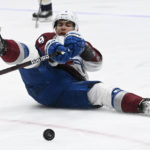 
              Colorado Avalanche center Evan Rodrigues (9) falls to the ice as he reaches for the puck during the first period of an NHL hockey game against the Nashville Predators Friday, Dec. 23, 2022, in Nashville, Tenn. (AP Photo/Mark Zaleski)
            