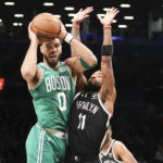 
              Boston Celtics forward Jayson Tatum (0) looks to pass the ball against Brooklyn Nets guard Kyrie Irving (11) during the first half of an NBA basketball game, Sunday, Dec. 4, 2022, in New York. (AP Photo/Jessie Alcheh)
            