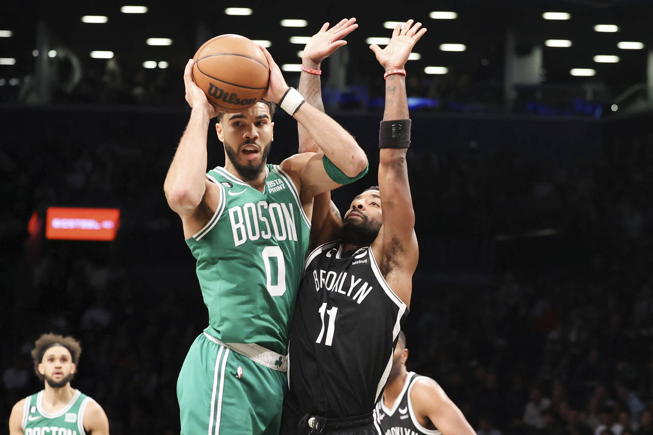 Boston Celtics forward Jayson Tatum (0) looks to pass the ball against Brooklyn Nets guard Kyrie Ir...