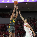 
              North Carolina A&T guard Demetric Horton (24) takes a shot over Houston guard Ramon Walker Jr. (3) during the first half of an NCAA college basketball game, Tuesday, Dec. 13, 2022, in Houston. (AP Photo/Kevin M. Cox)
            