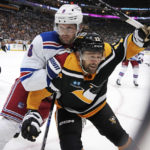 
              New York Rangers' Jacob Trouba (8) checks Pittsburgh Penguins' Bryan Rust (17) into the boards during the second period of an NHL hockey game in Pittsburgh, Tuesday, Dec. 20, 2022. (AP Photo/Gene J. Puskar)
            