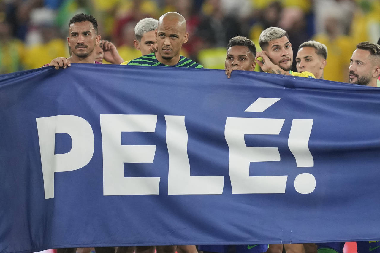 Brazilian players hold a banner in honour of the 82-year-old Brazilian soccer legend Pele who is in...