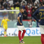 
              France's Kylian Mbappe, center, stands after England's Harry Kane scored his side's first goal during the World Cup quarterfinal soccer match between England and France, at the Al Bayt Stadium in Al Khor, Qatar, Saturday, Dec. 10, 2022. (AP Photo/Abbie Parr)
            