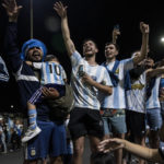 
              Soccer fans wave at the bus taking the Argentine soccer team that won the World Cup to the soccer federation training grounds where they will spend the night after landing at Ezeiza airport on the outskirts of Buenos Aires, Argentina, Tuesday, Dec. 20, 2022. (AP Photo/Rodrigo Abd)
            