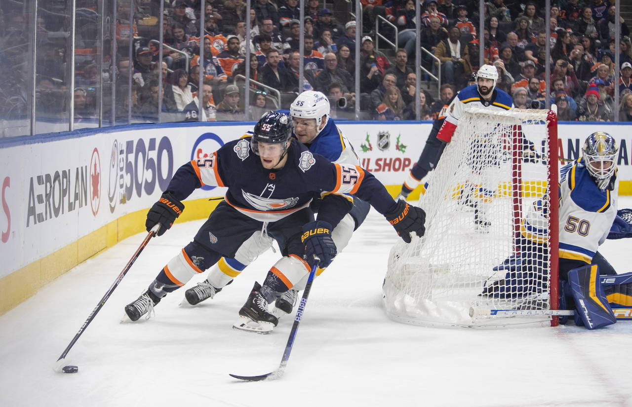 St. Louis Blues' Colton Parayko (55) and Edmonton Oilers' Dylan Holloway (55) fight for the puck be...